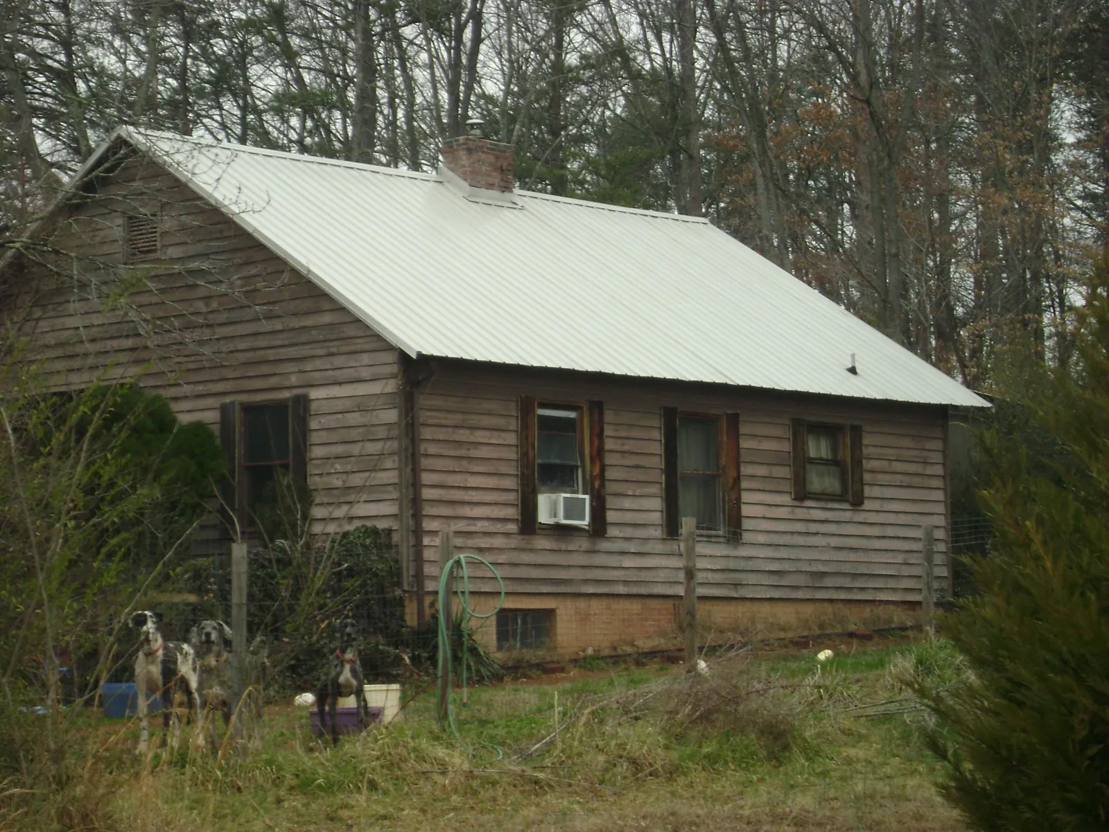 White metal roof on an old wood sided farmhouse, from a Metal Roof Installation job in Waveland
